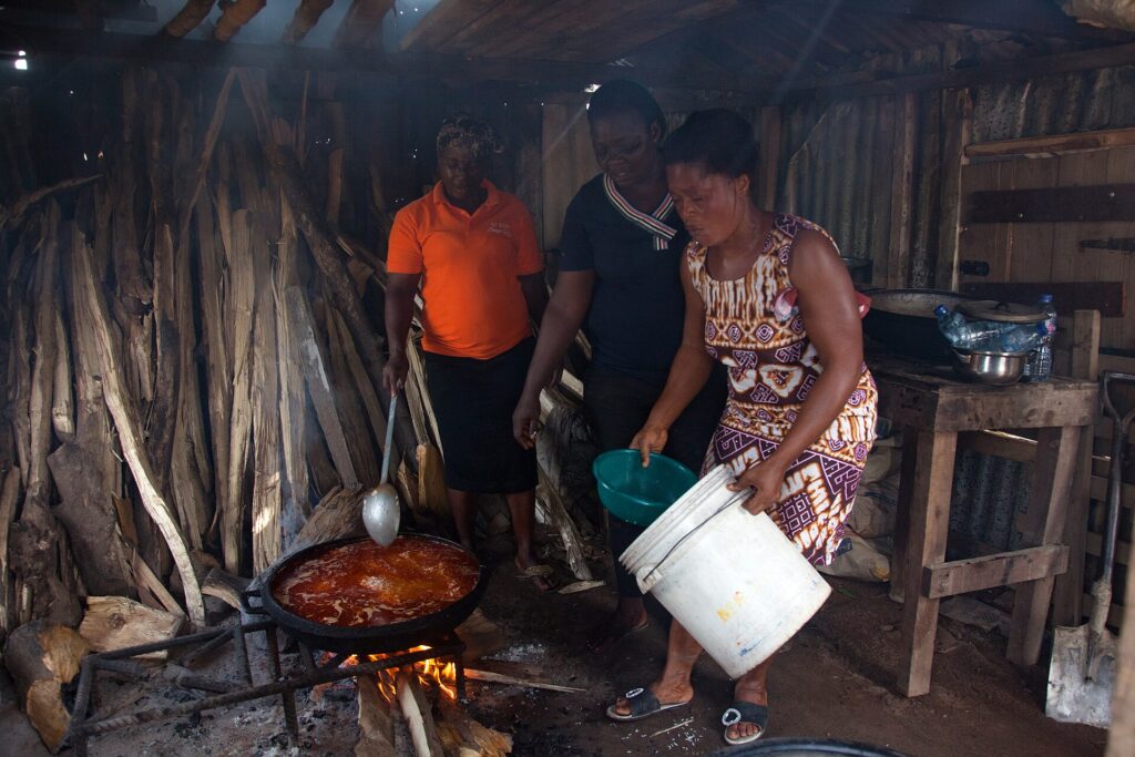 Community members cooking together over open fires
