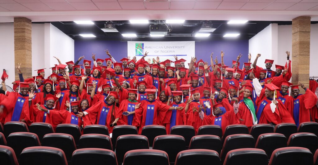 Graduating Nigerian university students in red gowns celebrating together